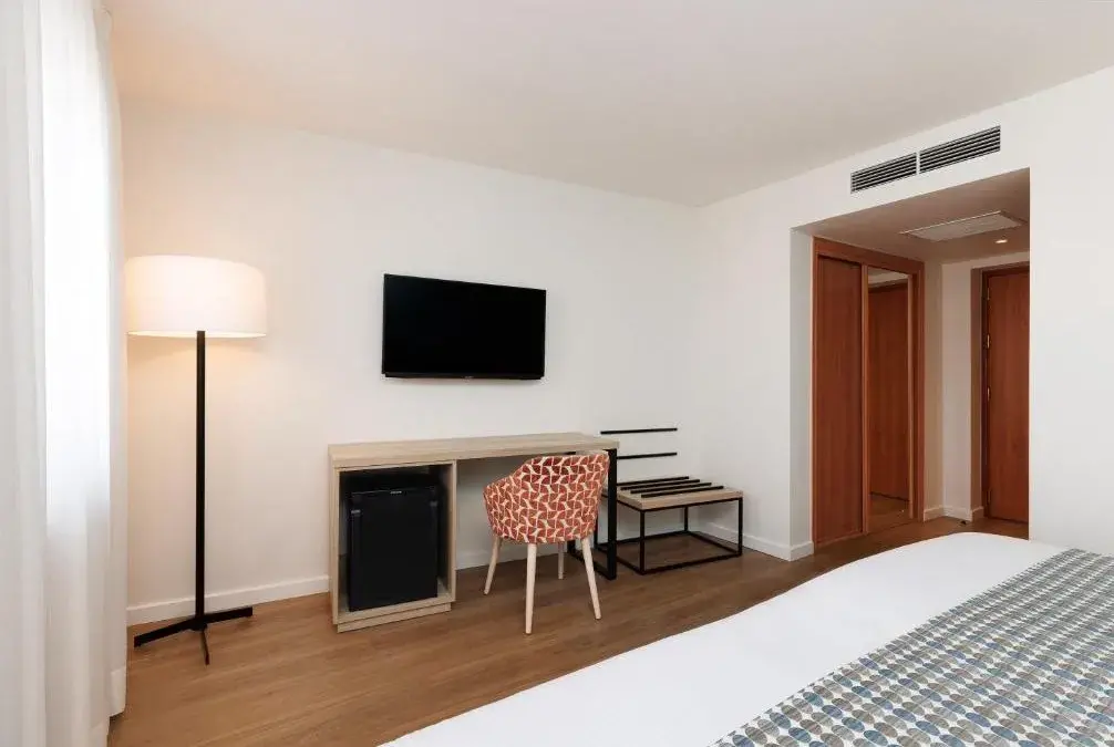 Guest room with desk and television at Exe Vienna Hotel